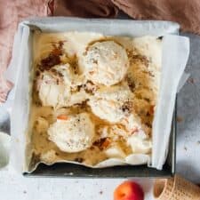 Apricot Crumble Semifreddo sits in a square metal tin on a light grey background.