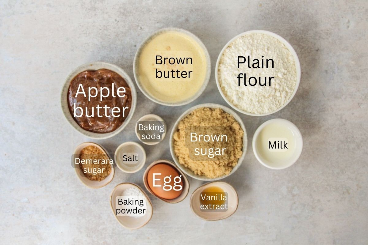 Ingredients for Apple Butter Cake sit in a series of bowls on a gray surface.