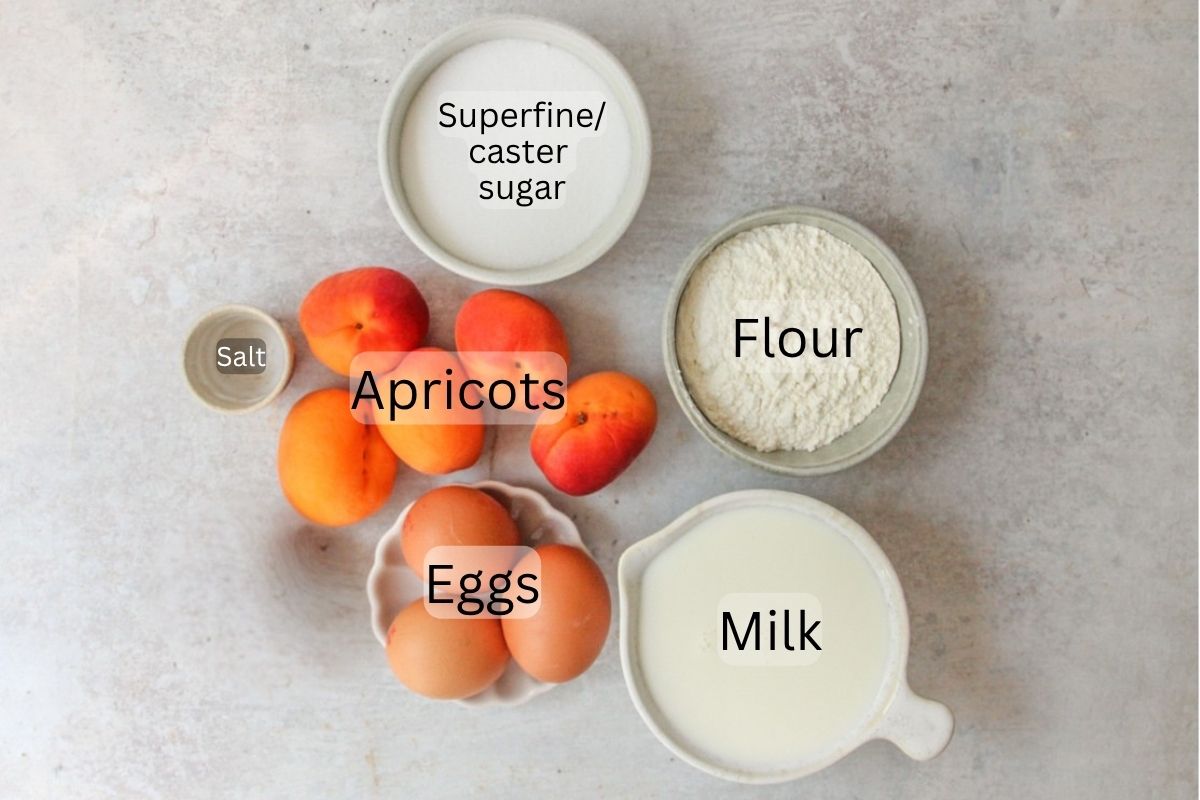 Ingredients for Apricot Clafoutis sit on a gray surface.