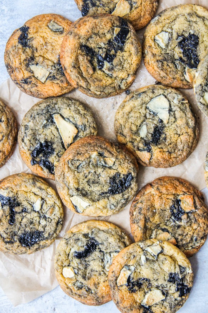 Swirled White Chocolate Black Sesame Cookies lay on parchment paper.