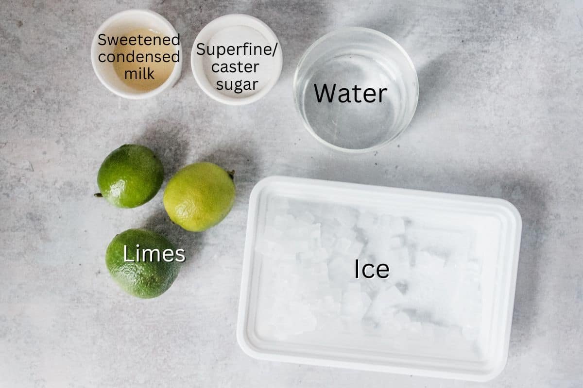 Brazilian Limeade Ingredients laid out on a grey surface in a series of dishes