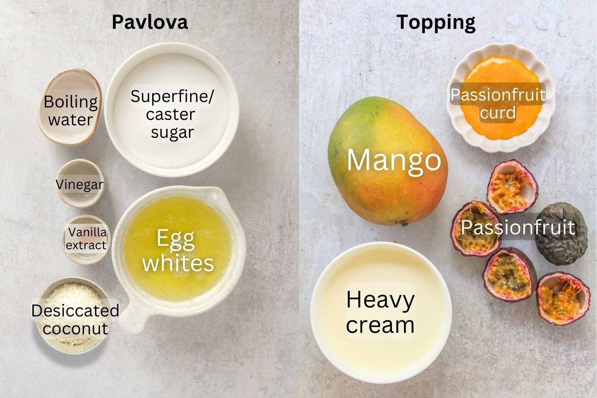 Ingredients for Coconut Mango Pavlova sit in a series of bowls and plates on a gray surface.