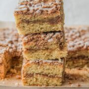 Three slices of Dairy Free Coffee Cake sit stacked on top of each other with the cinnamon streusel center and strewn glaze visible.