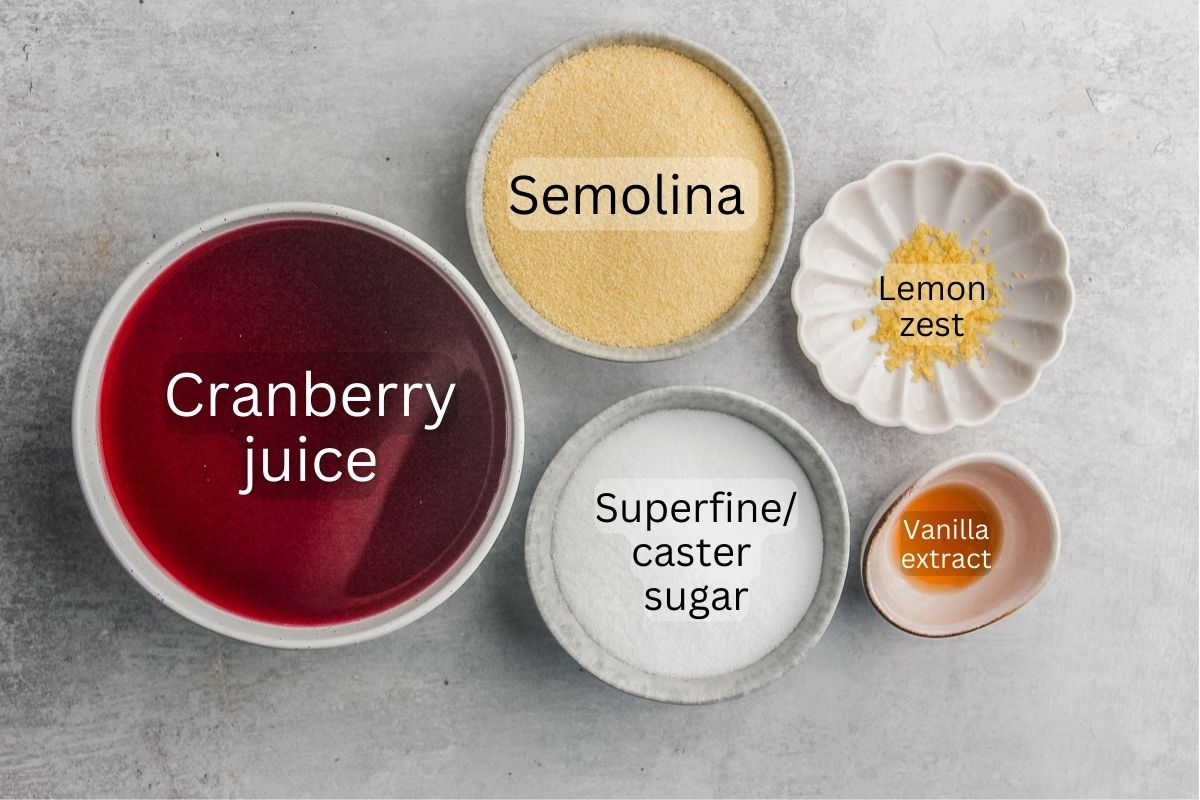 Ingredients for Estonian Cranberry Pudding sit in a variety of bowls and plates on a gray surface.