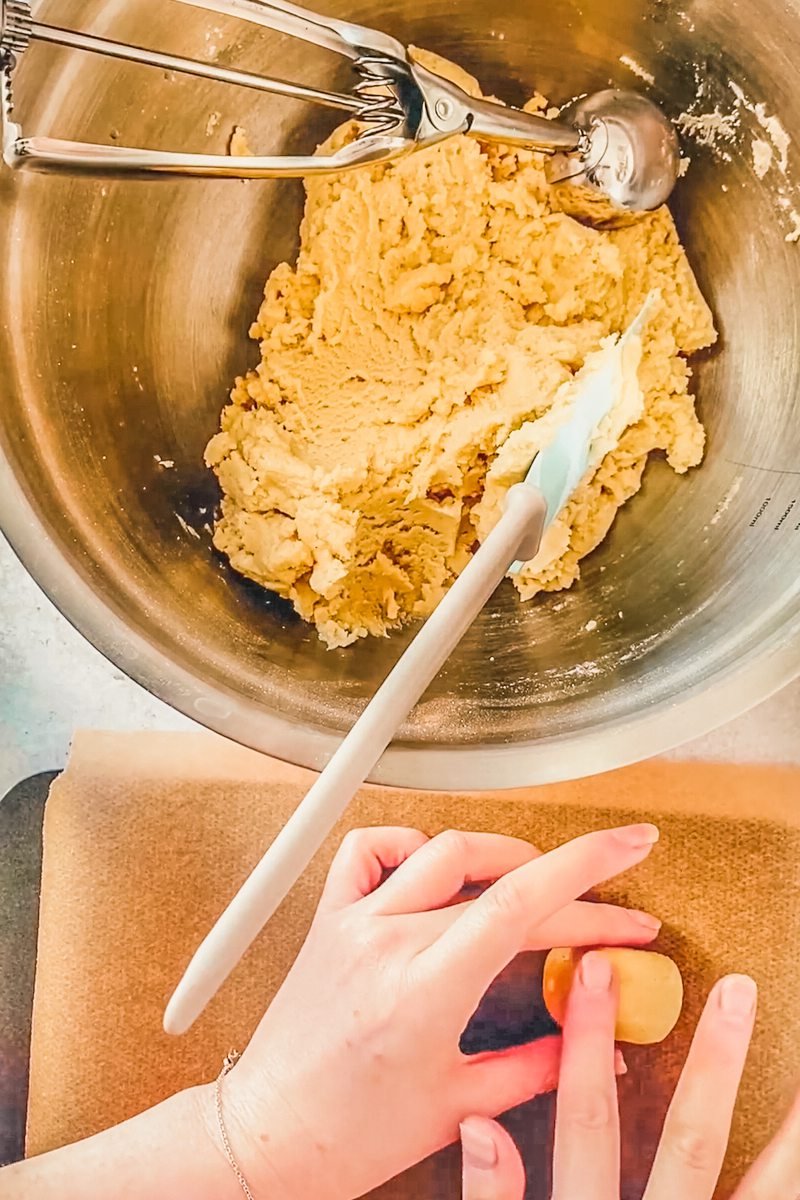 Greek walnut cookies are shaped into their signature oval shape on a parchment paper lined baking tray.