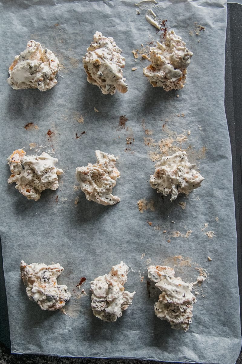 Icelandic cornflake and chocolate meringue cookies sit on a parchment paper lined baking tray.