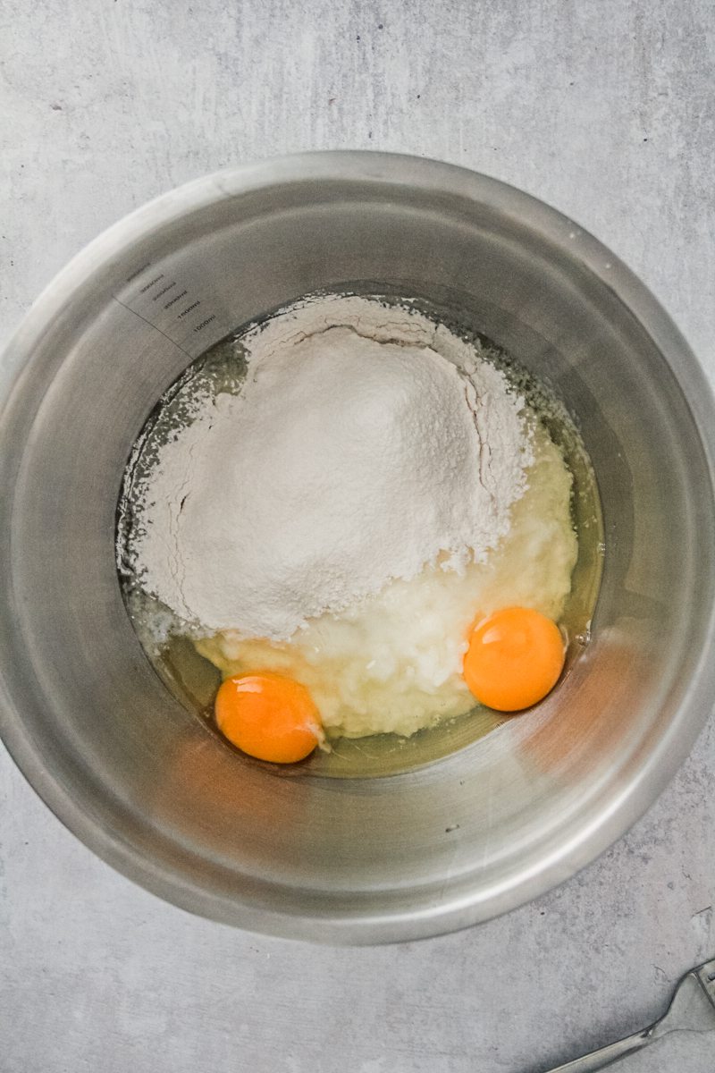 Rice pudding pancake batter mixture sits in a stainless steel bowl on a gray surface.