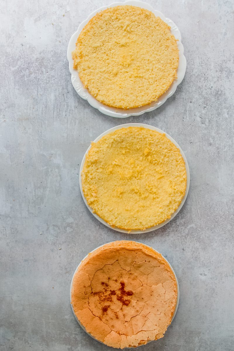 Cake divided into 3 layers sits on a gray surface.