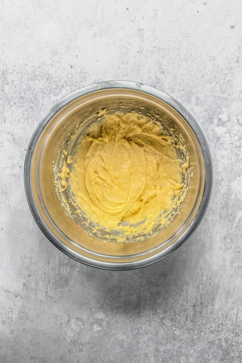 An almond frangipane sits in a stainless steel bowl on a gray surface.