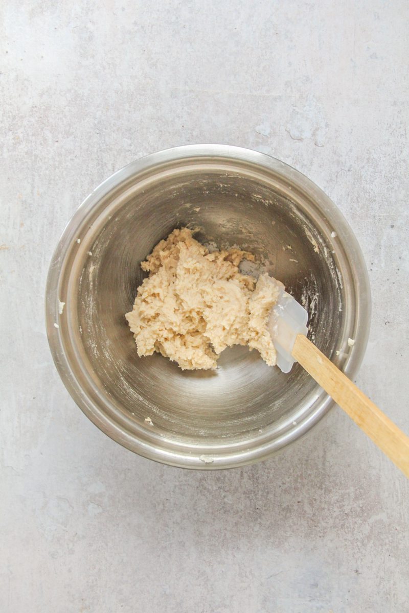 Dutch Lace Cookie dough sits in a stainless steel bowl on a gray surface.