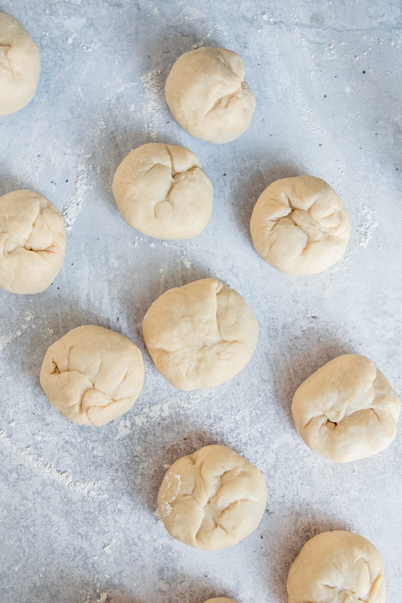 Kolache dough balls sit on a gray surface.