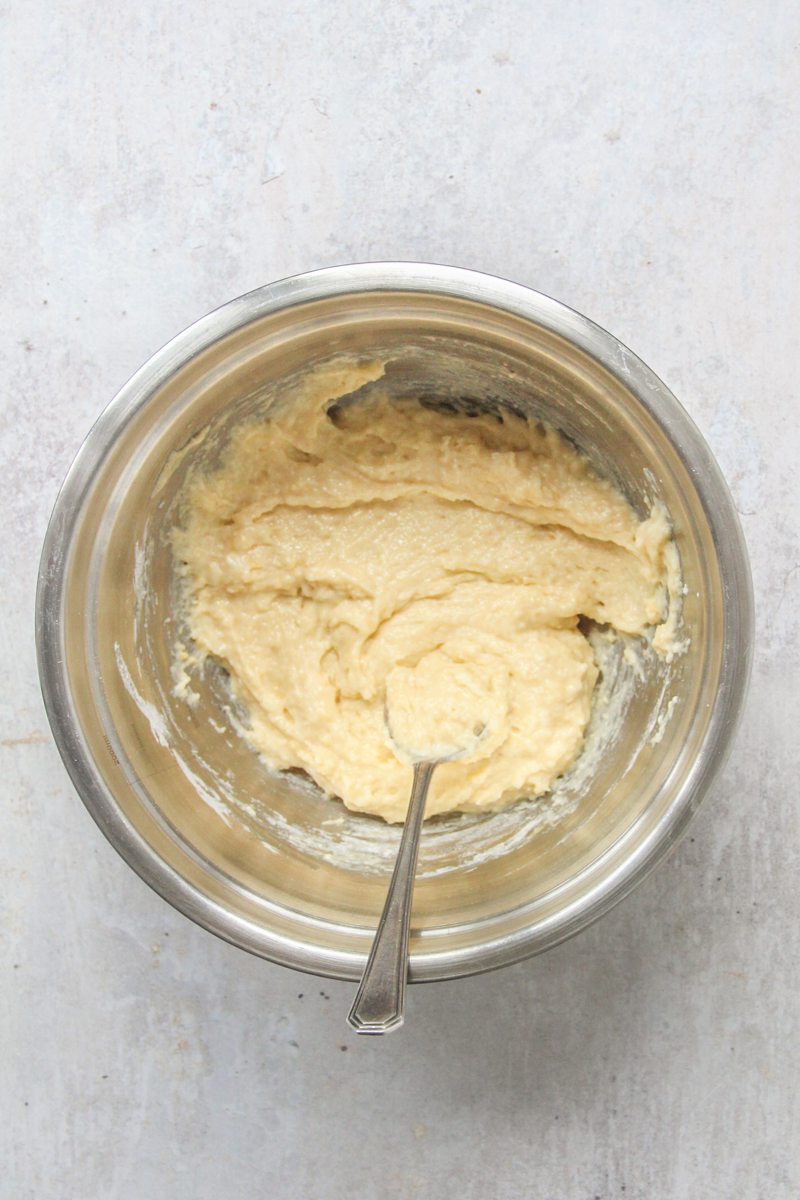 A kefir dough mixture sits in a stainless steel bowl on a gray surface.