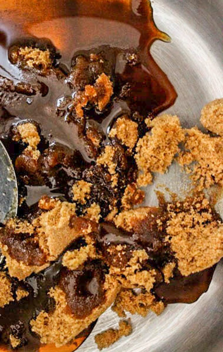 Sugar and maple syrup sits in a stainless steel saucepan.
