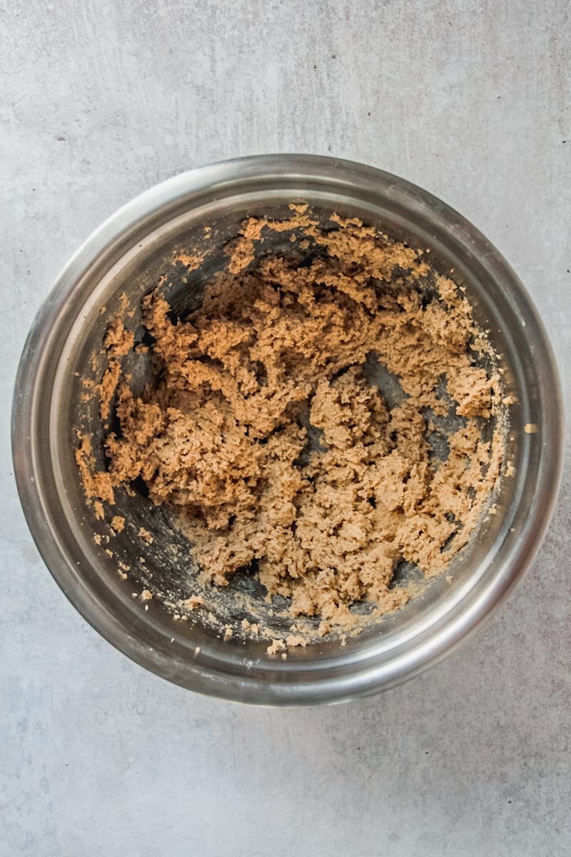 Whipped cookie batter sits in a stainless steel bowl on a gray surface.