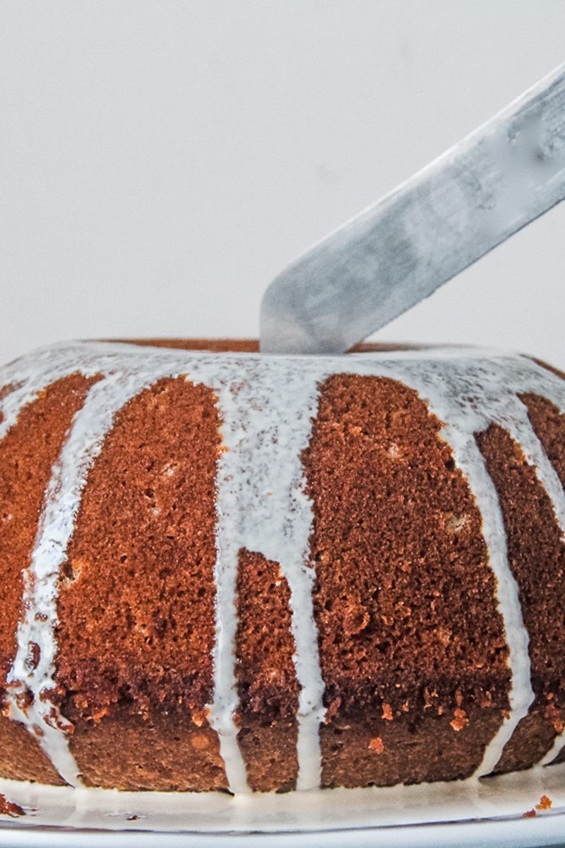 Burnt sugar steam pudding is sliced on a serving plate.