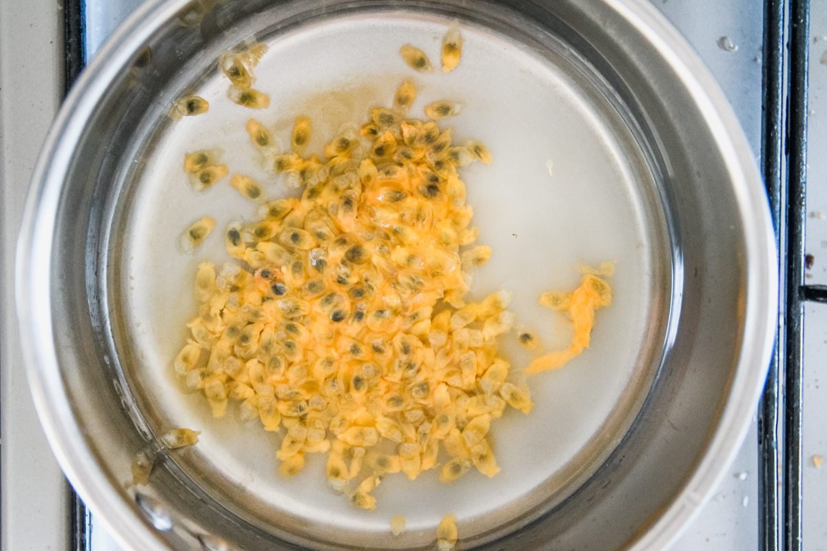 Passionfruit pulp sits in a small saucepan to make a syrup