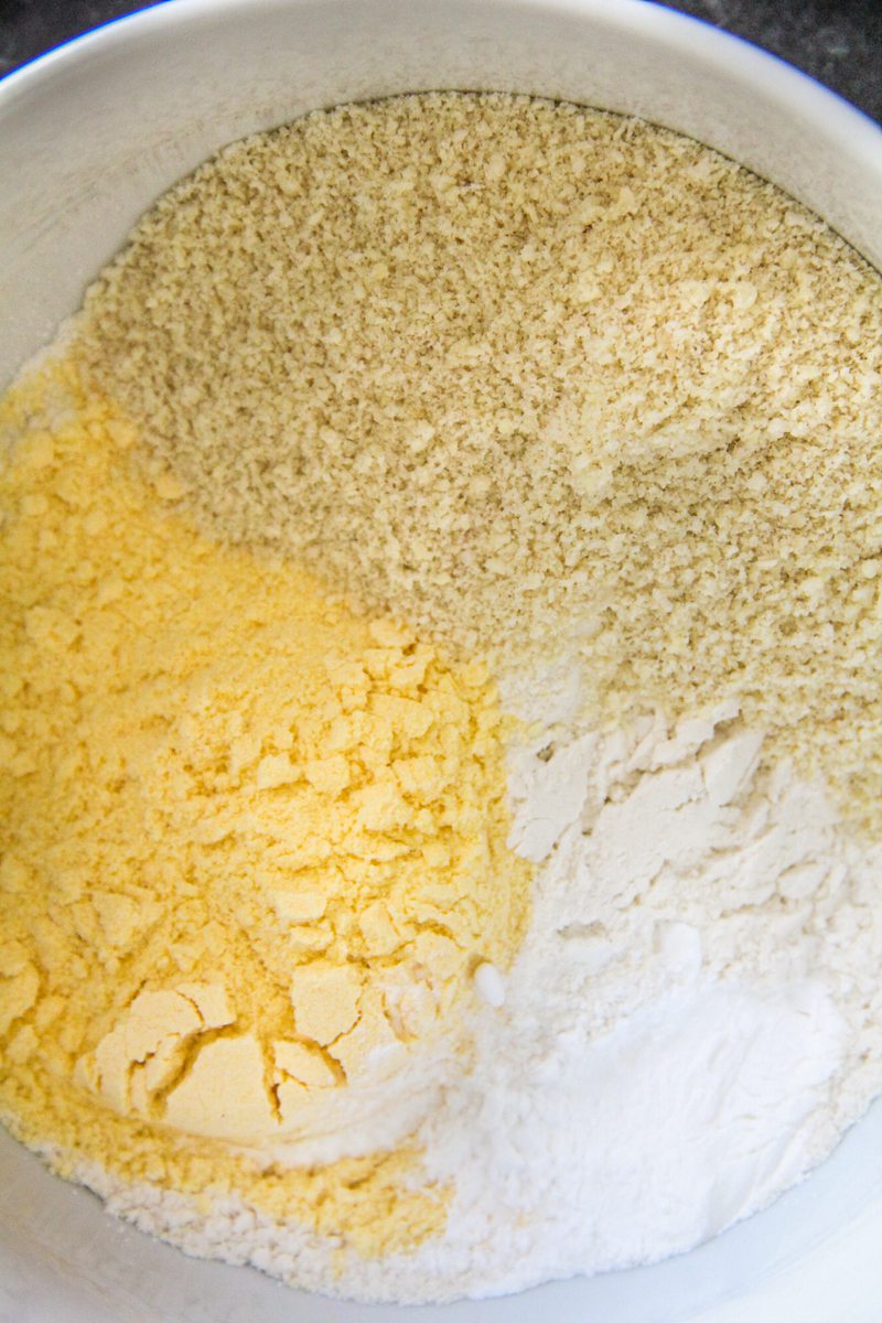 Polenta, ground almonds and flour sit in a white bowl.