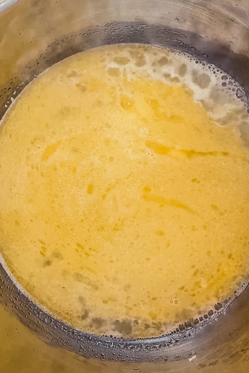 Butter and water simmers in a stainless steel saucepan.