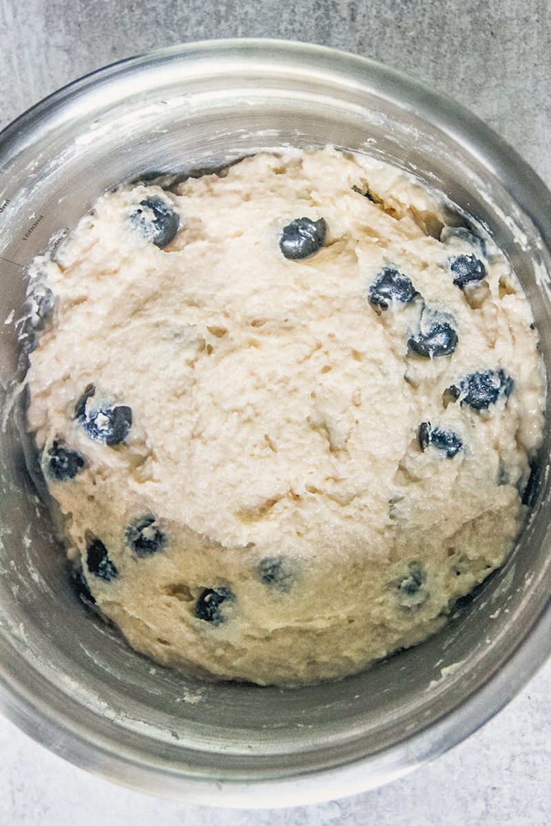 A blueberry steam pudding batter sits in a stainless bowl on a gray surface.