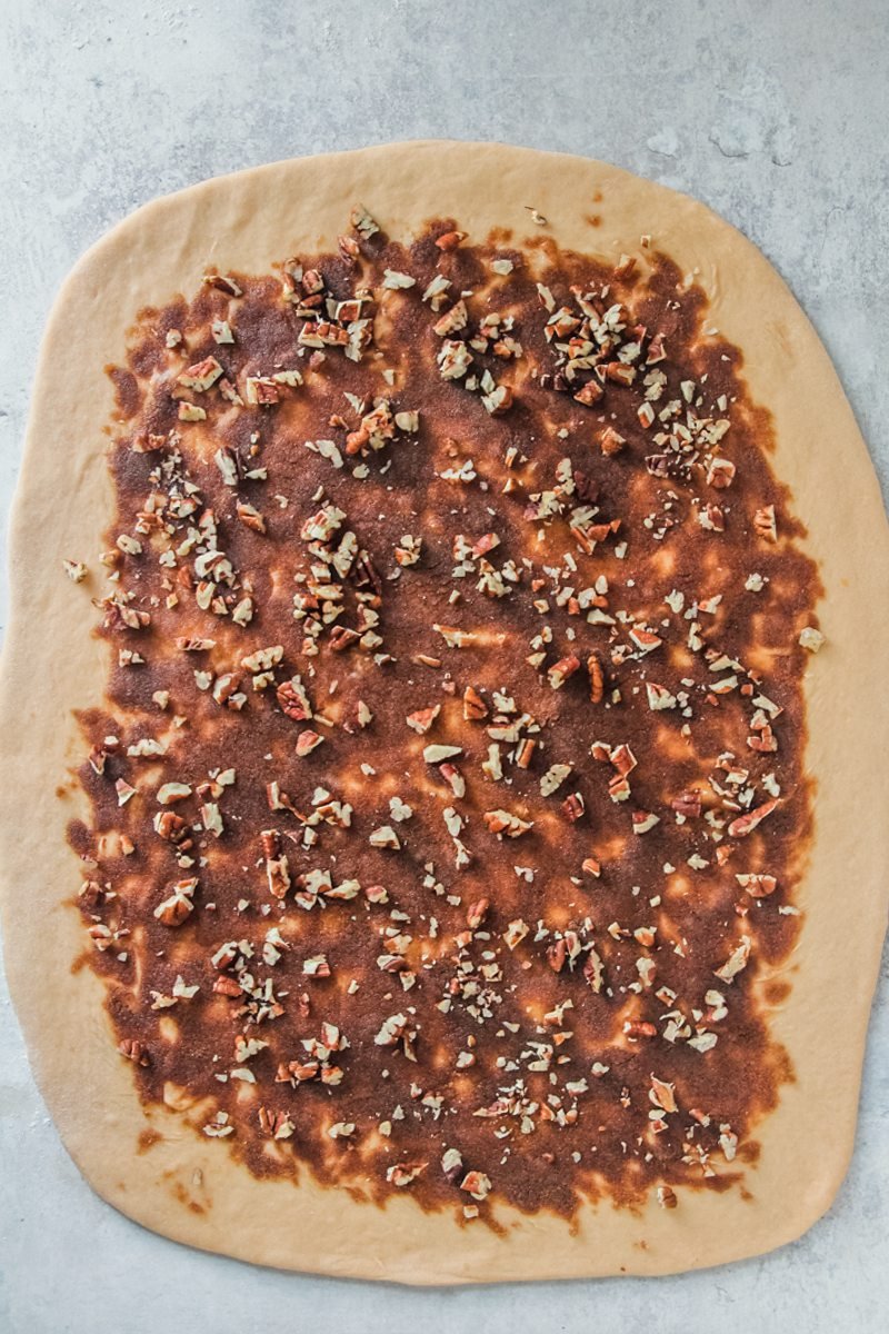 Sweet potato babka dough sits on a gray surface with the sugar and maple filling in the center with 1 inch edge.