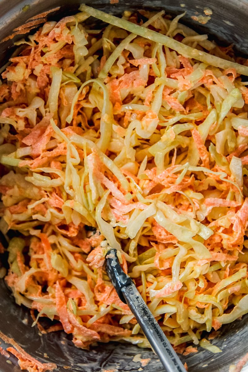 Homemade coleslaw sits in a stainless steel bowl.