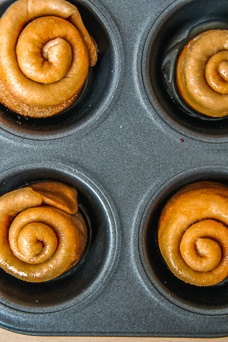 Unbaked Gemberbolus - Ginger Rolls sit in a muffin tin.