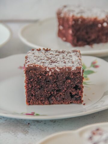 A slice of Icelandic chocolate cake sits on an individual plate on a light gray surface.
