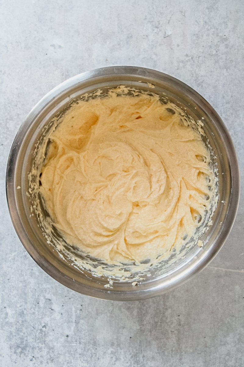 Spronge cake batter sits in a stainless steel bowl on a gray surface.