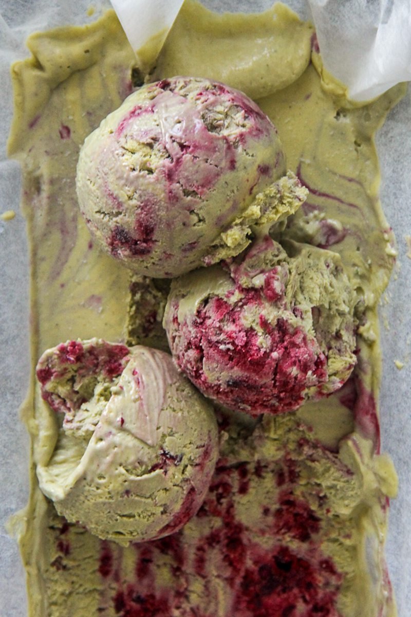 Scoops of matcha blackberry semifreddo sit on top of a tin of semifreddo.