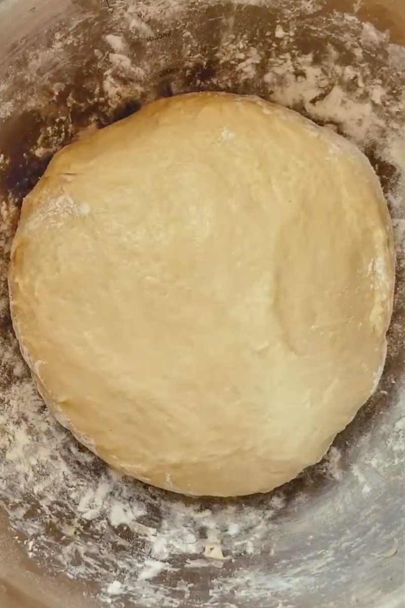 Kolache dough sits in a stainless steel bowl.