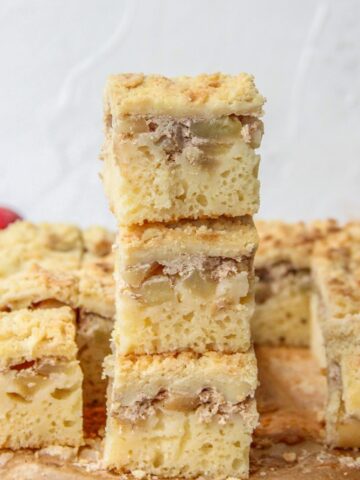 Apple bars sit on top of each other on parchment paper on a gray surface.