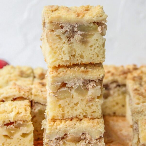 Apple bars sit on top of each other on parchment paper on a gray surface.