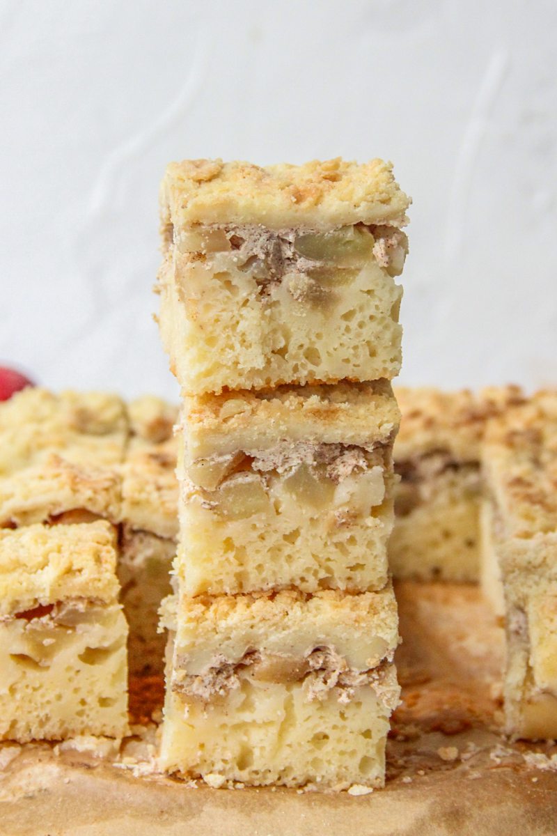 Apple bars sit on top of each other on parchment paper on a gray surface.