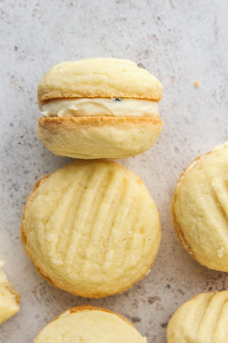 A Melting Moment lays on its side with it's passionfruit icing center visible.