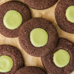 Chocolate Mint Thumbprint Cookies lay on parchment paper.
