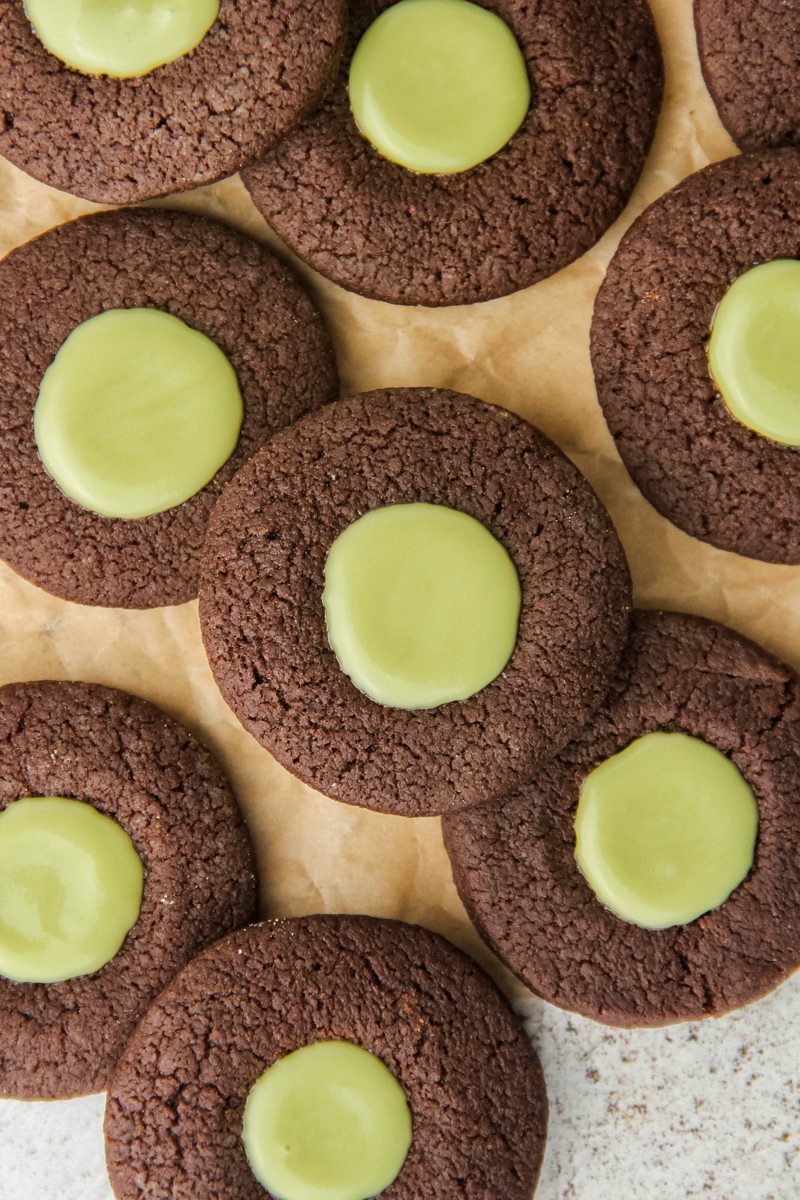 Chocolate Mint Thumbprint Cookies lay on parchment paper.