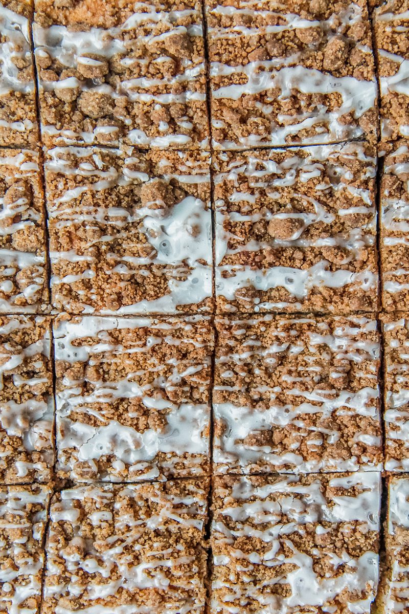 A close up of olive oil coffee cake slices drizzled with glaze.