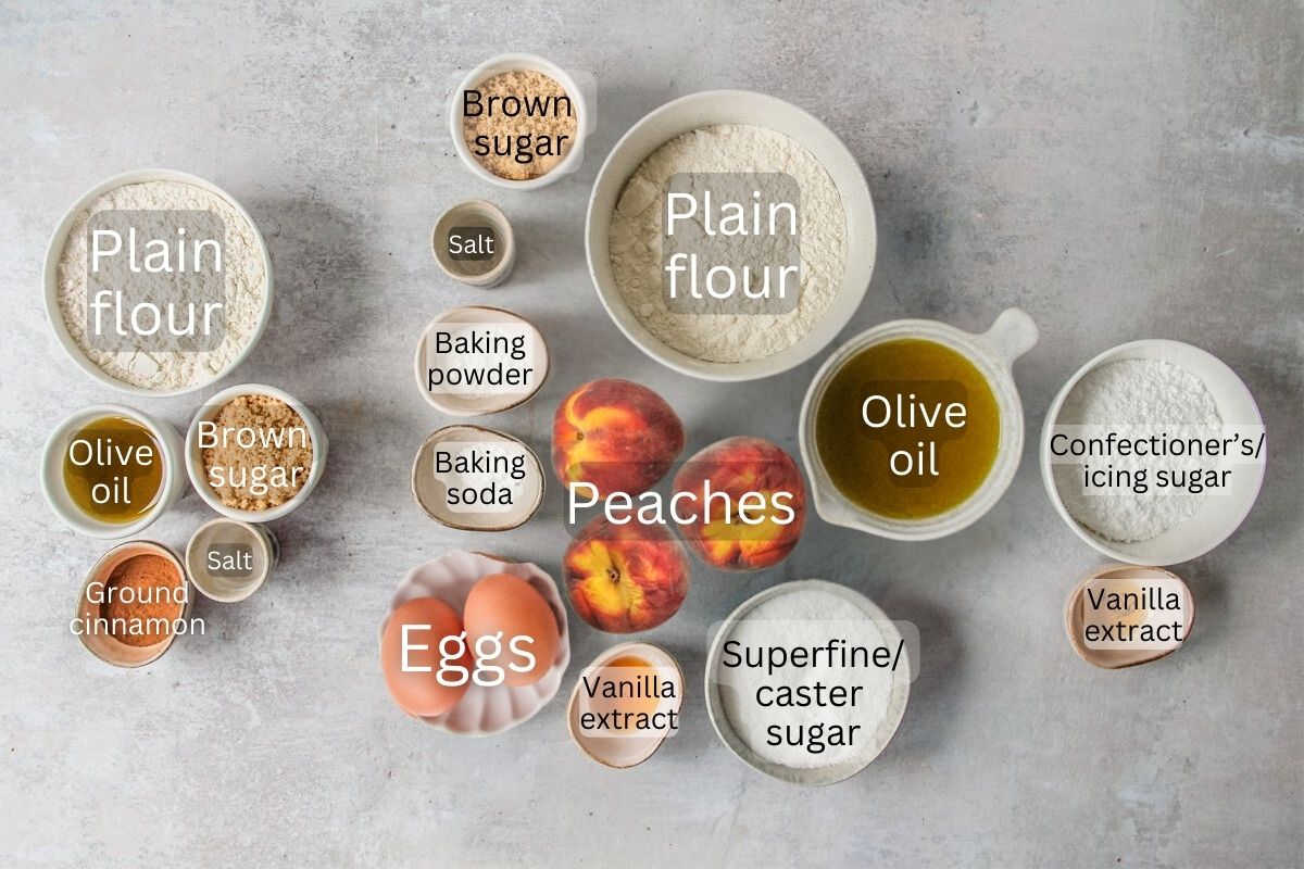 Ingredients for Peach Crumb Cake sit in a series of bowls on a gray surface.
