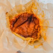 Portuguese Pao de Lao sits in traditional parchment paper on a light gray surface with a coral cloth beside.