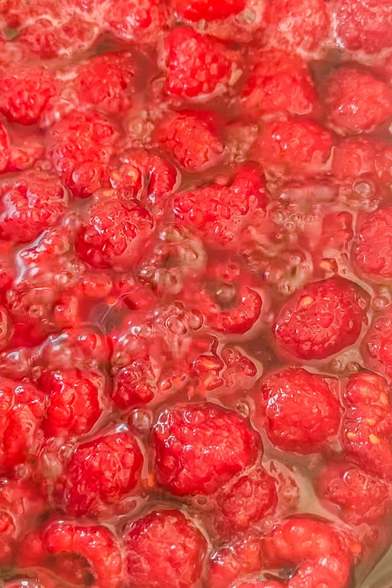 Raspberries simmer into a homemade jam.