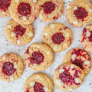 Raspberry White Chocolate cookies sit on a light gray surface.
