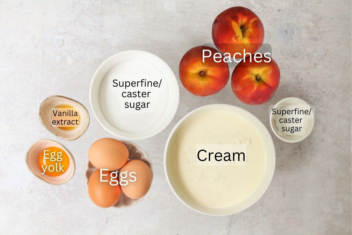 Ingredients for Roasted Peach Semifreddo sit in a series of bowls on a gray surface.