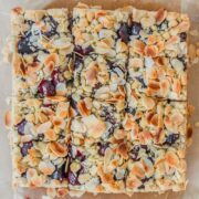 An overhead shot of Latvian Sweet Cherry Crumb Cake sits sliced up on parchment paper.