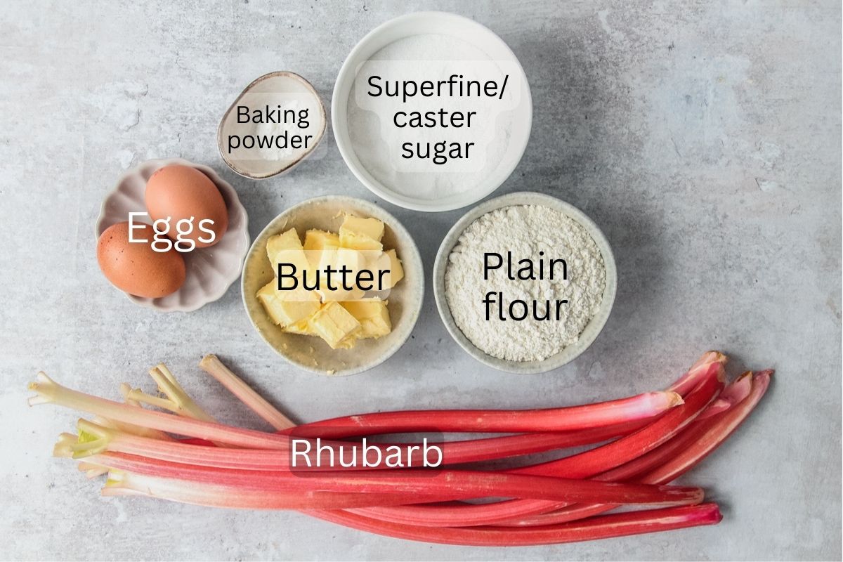 Ingredients for Scottish Rhubarb Pudding sit in a series of bowls on a gray surface.