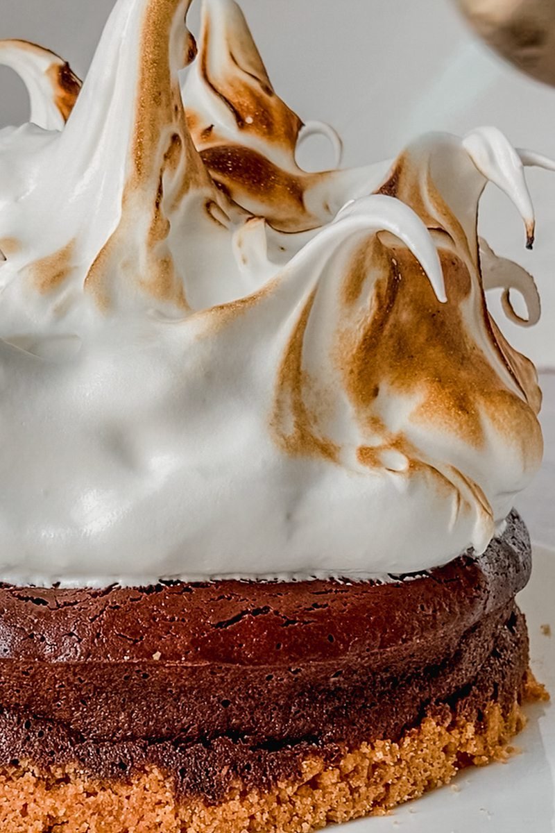 A marshmallow topping is caramelized with a blow torch on a smore pie.