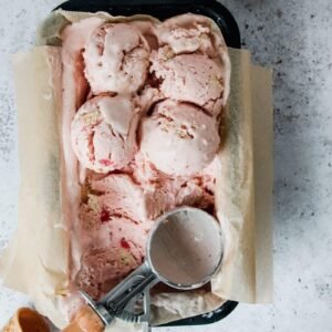 Scoops of Strawberry Shortbread Semifreddo sit in the tin ready to be served, sitting on a light grey background.