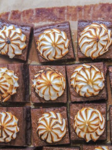 Sweet Potato Bars sit on parchment paper with caramelized meringue topping.