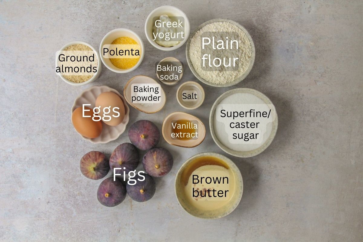 Ingredients for Upside Down Fig Cake sit in a series of bowls on a gray surface.