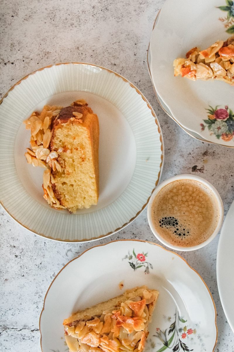 Slice of Swedish Almond Cake sit on a ceramic plates on a light gray surface.