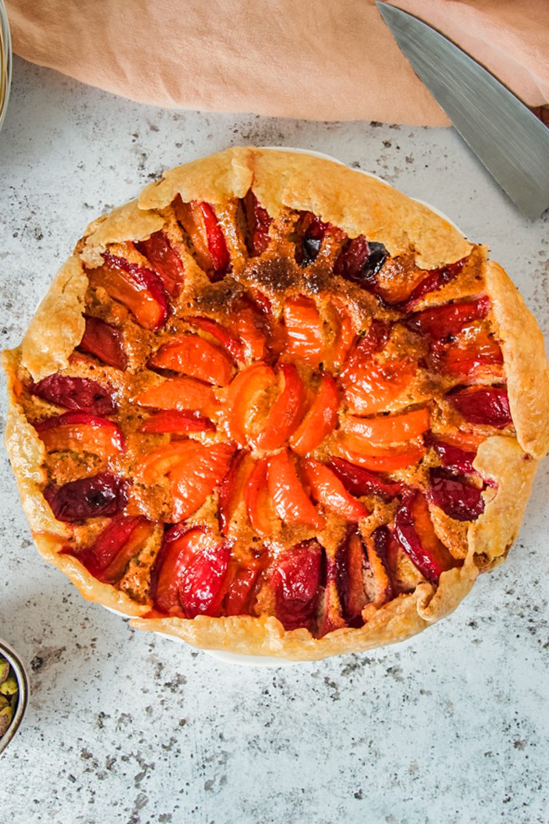 An apricot galette sits above a light gray surface.